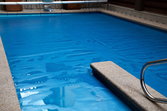 The surface of the pool is covered with a protective coating. Winter season and pool maintenance, pool protection. Selective focus.