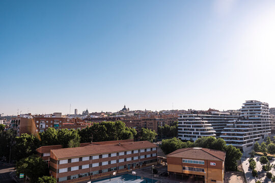 scenic view of modern apartment buildings in Arganzuela District , traditional residential blocks, and lush green trees in Madrid, Spain