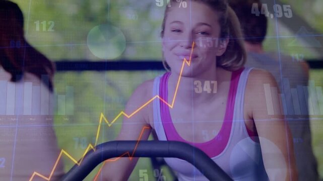 Woman pedaling bike in gym, glancing at console as animated graphs rising and tracking performance