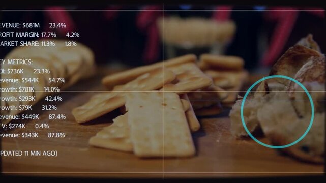 Close shot showing crackers and torn bread on board, blue reticle initiating HUD with finance data