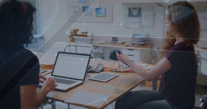 Left man reaching toward laptop, right woman lifting folio and spreading swatches for design review