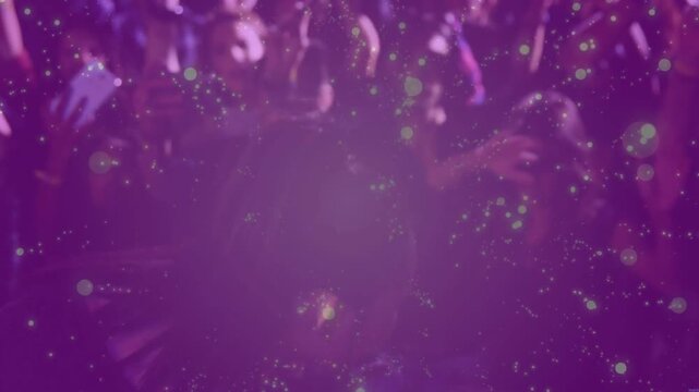 Male singer moving through concert singing into blue mic engaging fans, purple glow washing phones