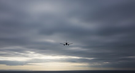 Obraz premium Airplane flying over ocean at sunset