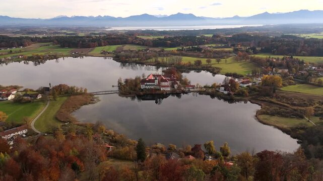 Aerial landscape showing Kloster Seeon Monastery on Lake Seeon, near Chiemsee and the Bavarian Alps, Upper Bavaria, Germany. Luftaufnahme des Kloster Seeon in Seeon-Seebruck, Oberbayern, Deutschland