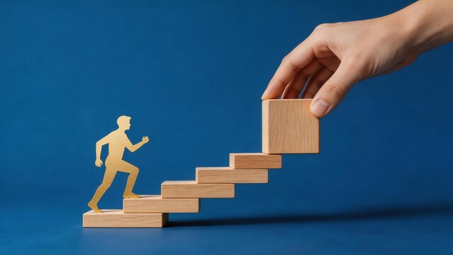 Hand placing wooden blocks for paper figure to climb
