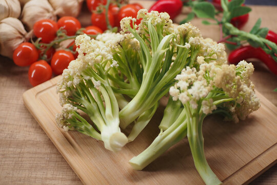 Fresh broccolini on a wooden board with other vegetables