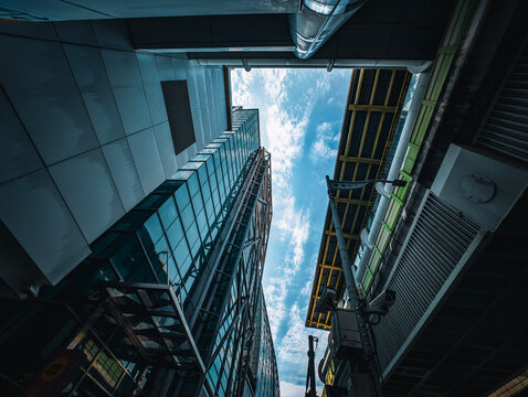 Low-angle perspective of towering glass skyscrapers reaching toward the blue sky