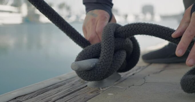 Technician Securing Boat Rope at Dockside