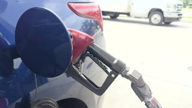 Gas nozzle in car filling at station 4k