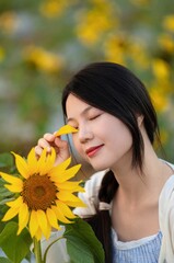 Naklejka premium Asian beauty in a sunflower field