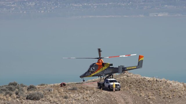 Circa March, 25, 2026 - West Mountain Utah - Helicopter taking flight in slow motion in front of Utah Lake during training for the fire season.