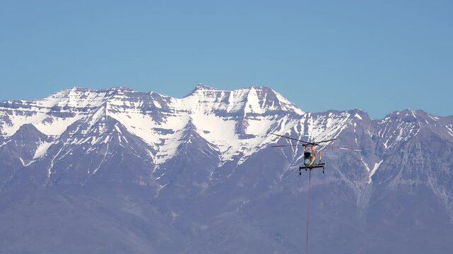 Circa March, 25, 2026 - West Mountain Utah - Helicopter taking flight in slow motion in front of Utah Lake during training for the fire season.