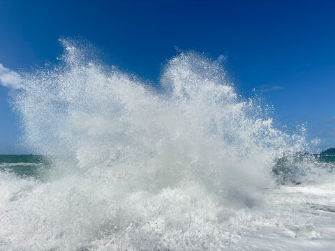 Powerful ocean wave crashing against rock with white water splash