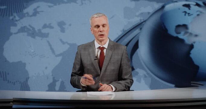 Serious Mature Man Journalist in Formal Grey Jacket and Red Tie Speaking With Authority. International Relations, International Summit Coverage, Review of Financial Issues From Various Perspectives.