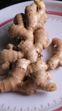 Close-up of Fresh Raw Ginger Roots on a Ceramic Plate