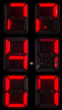 A close-up of a digital clock display with red LED numbers