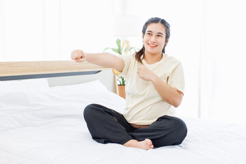 Obraz premium Asian happy young calm pregnant woman doing practicing yoga stretching muscles on white bed in bedroom at home fitness exercises indoor, healthy pregnancy lifestyle maternity love wellness motherhood.