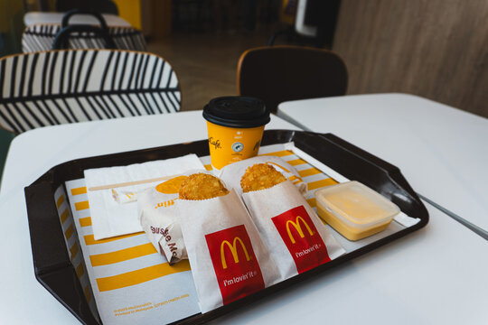 THAILAND - APRIL 4, 2026: An angled view of a McDonald's breakfast meal on a tray, featuring hash browns, a wrapped Sausage McMuffin, dipping sauce, and a McCafe coffee.