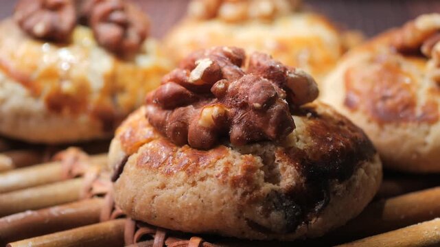 Freshly baked walnut cookies on wooden surface close up cinematic slow motion food footage.