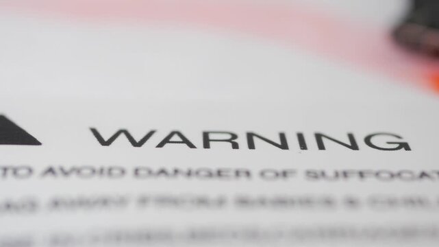 Close up on warning label text about danger of suffocation to babies.