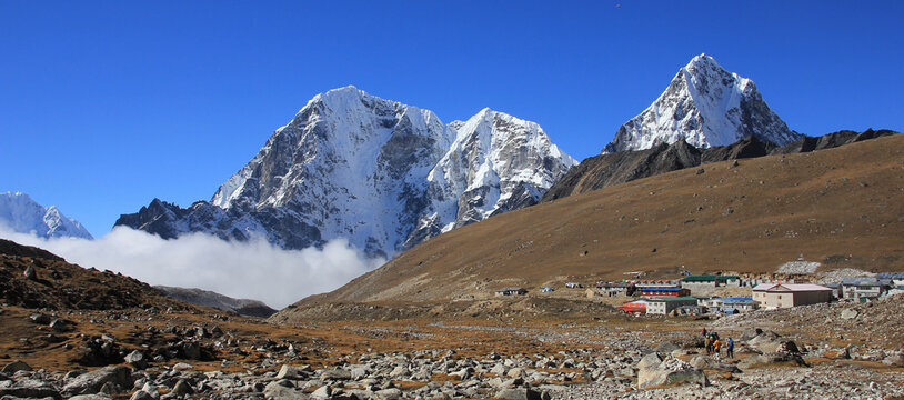 Mountain lodges in Lobuche and snow covered mountains Tobuche, Taboche and Cholatse, Nepal.