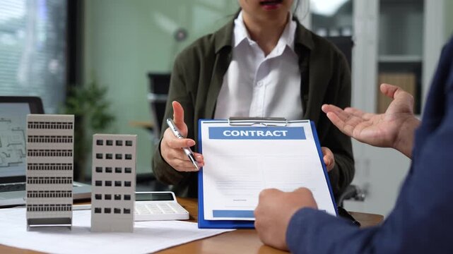 Real estate broker agent presenting and consult to customer to decision making sign insurance form agreement, home model, concerning mortgage loan offer in office.