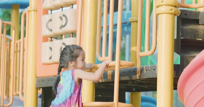 Little kindergarten girl enjoy climb on slider outdoor playground city park active learnning
