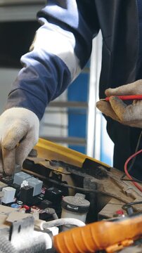 Mechanic in gloves checks electro fuse relay - electric components in car - automobile service diagnostics