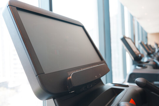 Close-up of a treadmill control screen in a modern fitness center with natural lighting