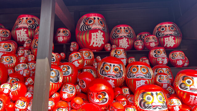 大阪箕面市の勝尾寺に奉納された数多くの勝ち運だるま、願いが叶った象徴としての赤いダルマの群像、日本の伝統文化と縁起物の風景、目標達成や成功をイメージさせる高品質な文化観光素材。