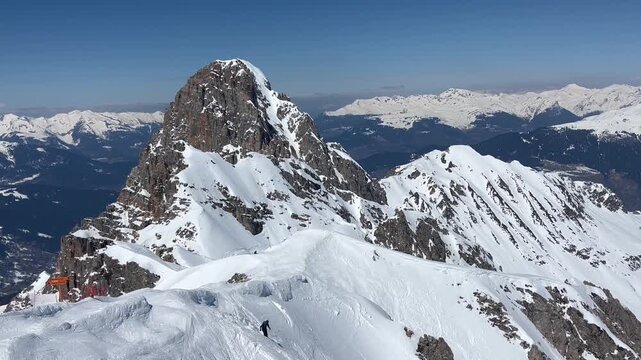 Skiers on extreme off slope in French alps in Courchevel ski resort with a massif mountain in the background