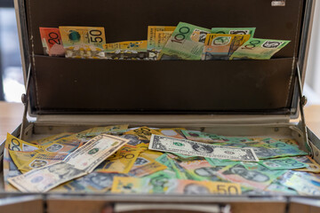 Open briefcase full of international banknotes including dollar and various currencies, representing global finance, wealth, cash flow, investment international business economy concept. © Smallroombigdream