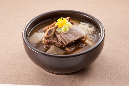 Traditional Korean beef short rib soup, Galbitang, with radish and glass noodles in a ceramic bowl.