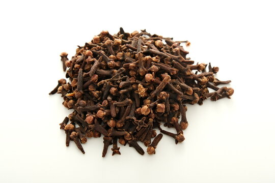 Dried clove buds piled on a white background for culinary and medicinal use