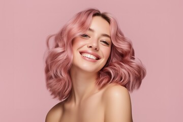 Naklejka premium Happy young woman with wavy pink hair and beautiful smile on pink background
