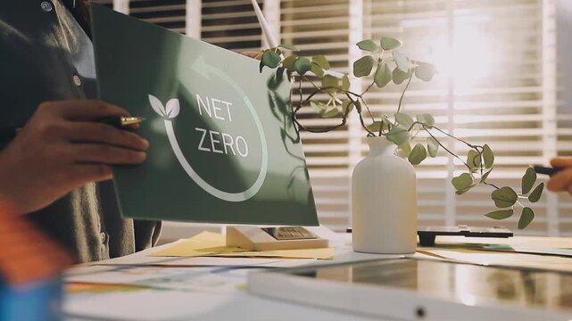 Business executives collaborating on environmental sustainability strategy utilizing renewable energy solutions to achieve net zero targets in corporate meeting.