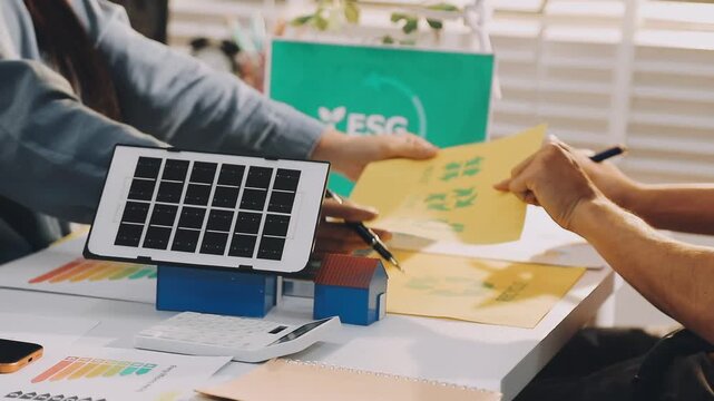 Business executives collaborating on environmental sustainability strategy utilizing renewable energy solutions to achieve net zero targets in corporate meeting.