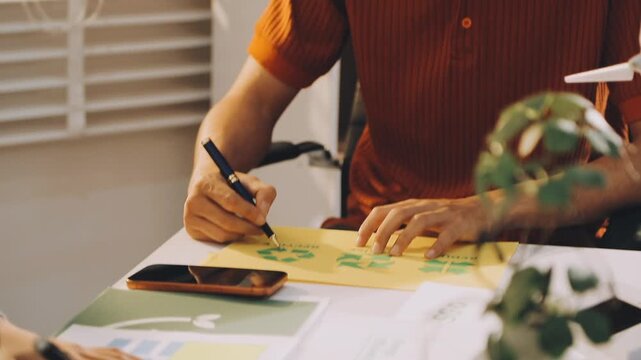 Business executives collaborating on environmental sustainability strategy utilizing renewable energy solutions to achieve net zero targets in corporate meeting.