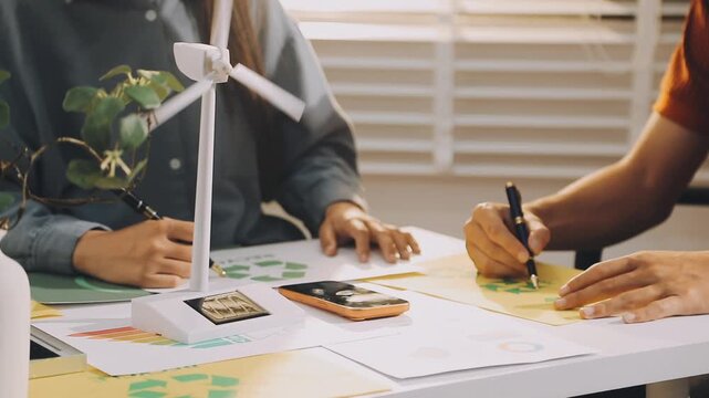 Business executives collaborating on environmental sustainability strategy utilizing renewable energy solutions to achieve net zero targets in corporate meeting.