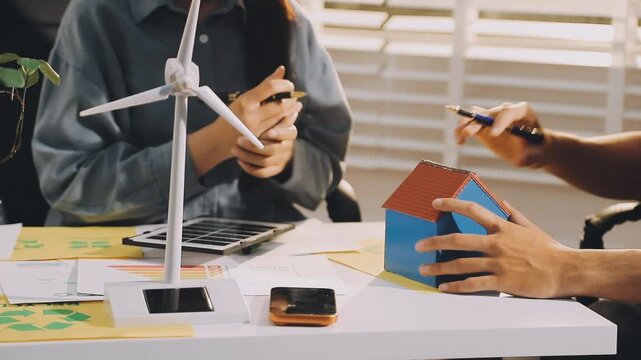 Business executives collaborating on environmental sustainability strategy utilizing renewable energy solutions to achieve net zero targets in corporate meeting.