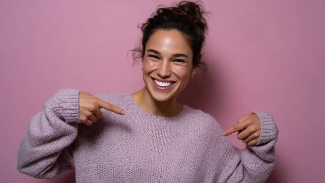 Young woman pointing at her bright white teeth smiling on pink studio background