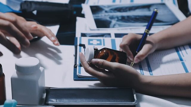 Professional physician working together at hospital, Latino woman doctor discussing with senior doctor for solution to treat patient in workroom.