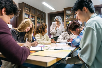 Fototapeta premium Diverse students studying together at a table while a stern teacher shushes for silence in a quiet library setting