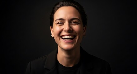 Obraz premium Portrait of a Woman Laughing Joyfully Against a Dark Background.