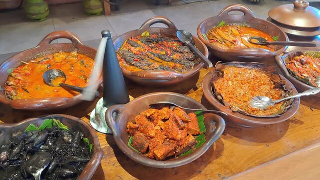 PAMEKASAN, INDONESIA - DECEMBER 17, 2025: Handheld footage inside a traditional Javanese joglo-style restaurant, showcasing authentic Indonesian cuisine, local vegetables, fish dishes, sambal, lalapan