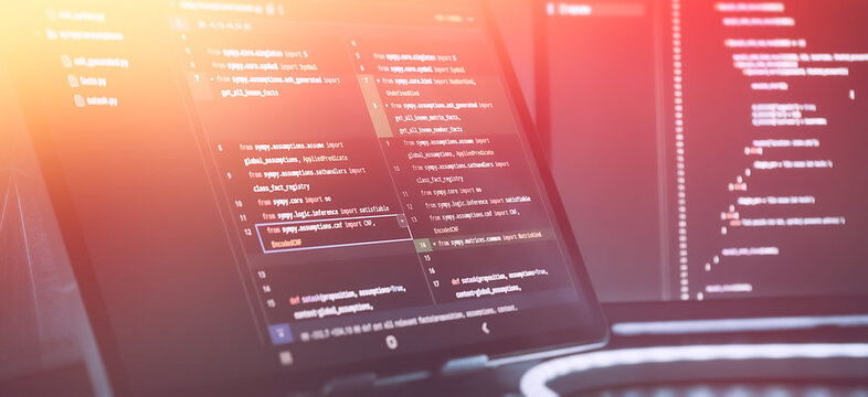 Futuristic Software Coding Workspace with Warm Gradient Light Overlay and Source Code on Screens