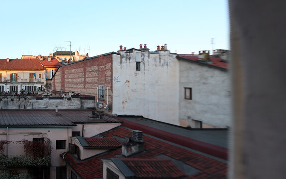Veduta panoramica sui tetti e sui ballatoi di tipiche case di ringhiera storiche a Torino illuminate dalla luce calda del tramonto