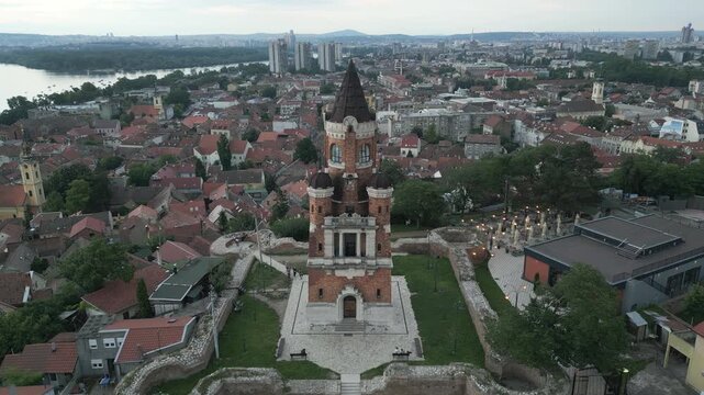 Aerial ascending shot revealing the historic Gardos tower and Zemun panorama at dusk, Belgrade, Serbia.