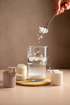 Collagen, creatin powder pouring in a glass. Food supplement, fitness sport, health and nutrition.