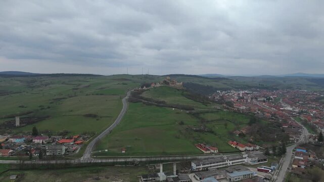 Aerial drone flying towards Rupea fortress over village